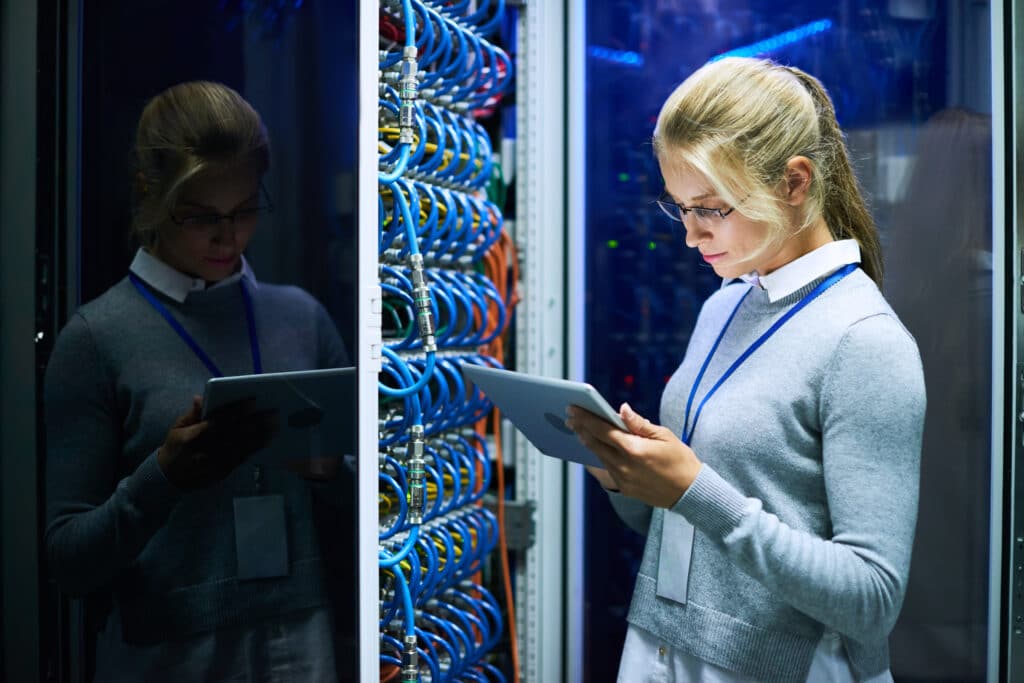 A woman checks a server cabinet